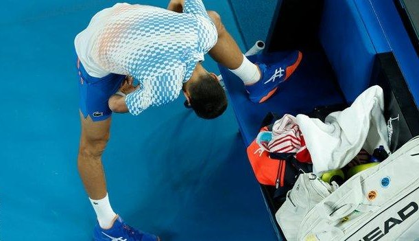 Novak Djokovic checks on his left hamstring.